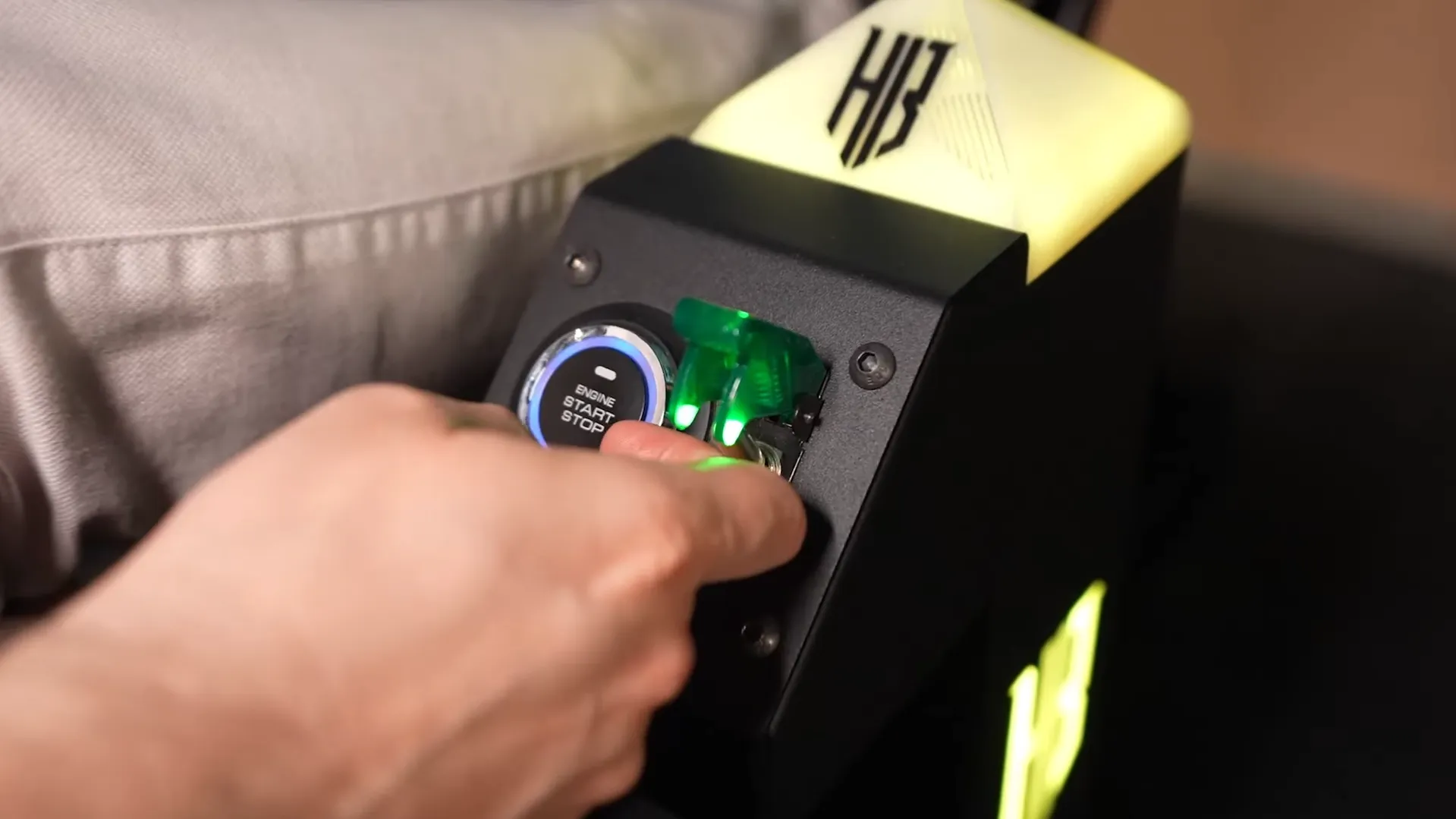 Kontrol kutusundaki Engine Start/Stop düğmesine basan el, yeşil emniyet anahtarı